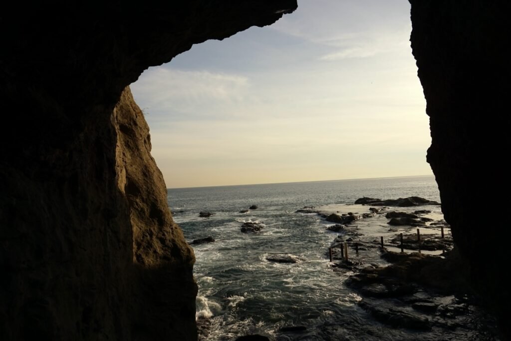 view of the ocean during sunset through a opening in the iwaya caves. 