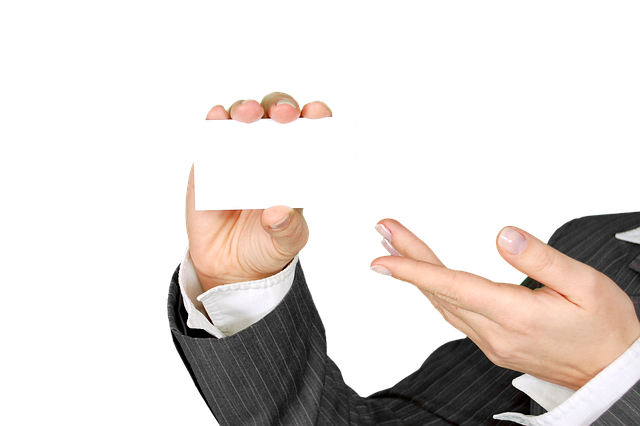Hand holding a card with 'King' written on it, with drinks in background