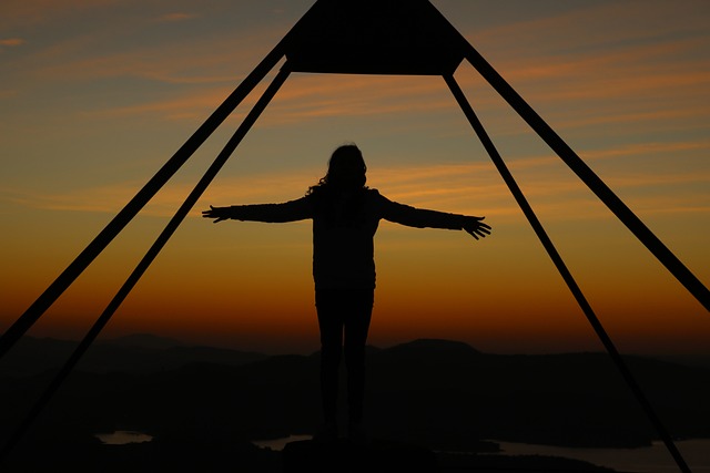 Person meditating at sunrise