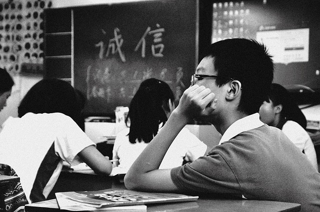 Young Black student looking sad while reading a book, illustrating emotional impact of biased material